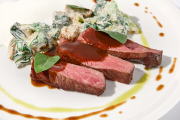 Beef steak with creamed spinach and mushrooms on elegant white dish, ideal for fine dining and gourmet cuisine