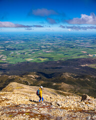 hiker girl walking down the steep trail from the top of mount somers in canterbury, new zealand...