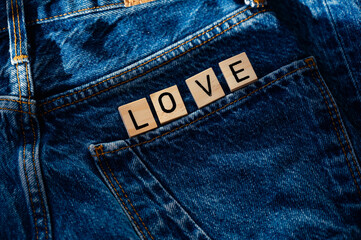 LOVE inscription on jeans. Denim. Valentine's Day concept. Denim Day. Love written on wooden signs