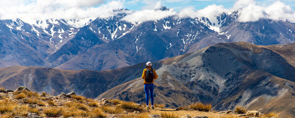 backpacker enjoying the stunning panorama of new zealand alps from the top of mount somers in...