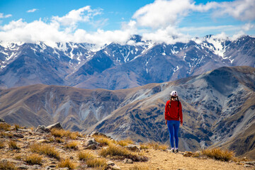 backpacker enjoying the stunning panorama of new zealand alps from the top of mount somers in...