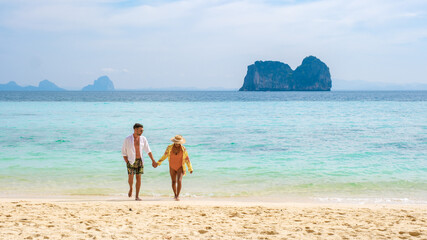 Fototapeta na wymiar a couple walking at the tropical beach of Koh Ngai island Trang in Thailand