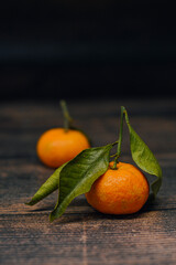 Fresh mandarin oranges fruit or tangerines on wooden table with leaves
