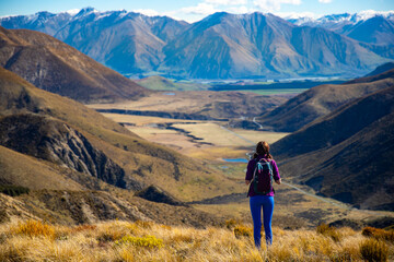 adventurous hiker girl on the way to the top of trig m, scenic peak in new zealand alps, near arthur's pass village and lake lyndon; 