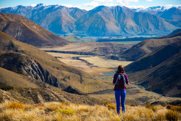 Fototapeta premium adventurous hiker girl on the way to the top of trig m, scenic peak in new zealand alps, near arthur's pass village and lake lyndon; 