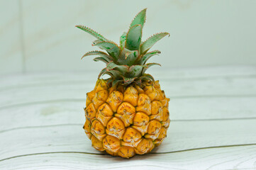Exotic pineapple on white wooden table, white background