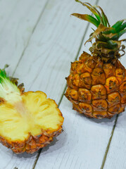 Sliced exotic pineapple on white wooden table