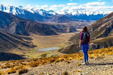 adventurous hiker girl on the way to the top of trig m, scenic peak in new zealand alps, near arthur's pass village and lake lyndon; 
