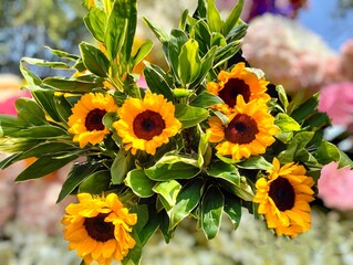 The background image was a blur of flowers. In the center of the image were six yellow sunflowers with green stems and leaves, embroidered and decorated very beautifully. © Chumsai
