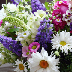 A beautiful summer bright bouquet of different flowers including sunflowers, roses, lavender and daisies