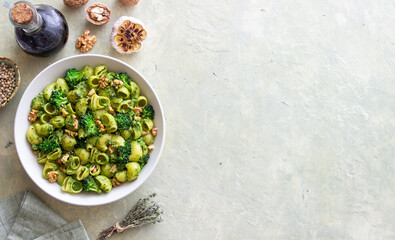 Pasta with broccoli, pesto sauce and nuts. Italian cuisine. Healthy eating.