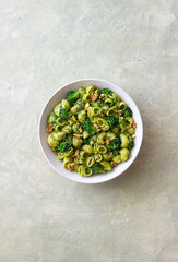 Pasta with broccoli, pesto sauce and nuts. Italian cuisine. Healthy eating.