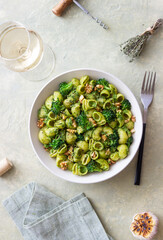 Pasta with broccoli, pesto sauce and nuts. Italian cuisine. Healthy eating.