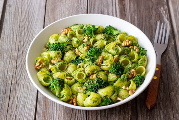 Pasta with broccoli, pesto sauce and nuts. Italian cuisine. Healthy eating.