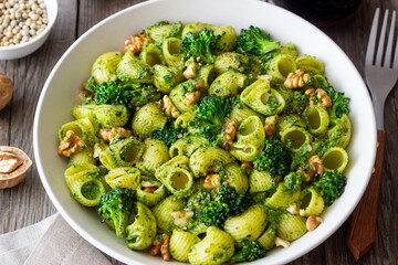 Pasta with broccoli, pesto sauce and nuts. Italian cuisine. Healthy eating.