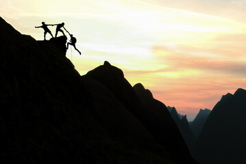 Harmonious climbers supporting each other and achieving success at the summit