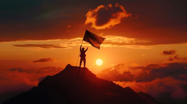 A man stands and plants a flag on the top of a high mountain. sunset silhouette