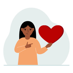A girl holds a big red heart in his hand. The concept of volunteering, romantic relationship or love.