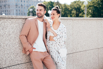 Beautiful fashion woman and her handsome elegant boyfriend in beige suit. Sexy brunette model in...