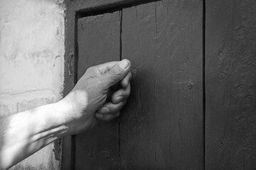 Man's hand knocking on the door