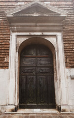 Fototapeta na wymiar Venetian Time Capsule: The Weathered Wooden Door