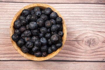 blueberries in a wooden bowl on a wooden background, healthy food, fruit in a bowl