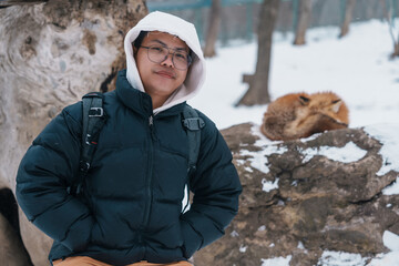 man tourist with Cute fox on snow in winter season at Zao fox village, traveler sightseeing Miyagi...