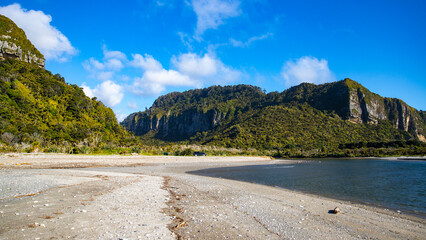 scenic west coast of new zealand south island; paradise beaches with large cliffs and little islands surrounded by rainforest covered mountains; paparoa national park near greymouth and westport