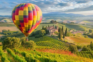 Foto auf Alu-Dibond Hot air balloon floating above a picturesque Tuscan landscape during the golden hour. Beautiful tuscan landscape in Italy on a sunny day in summer. Countryside landscape background. © Natasa