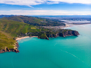 aerial panorama of godley heads near christchurch and lyttelton, canterbury, new zealand; turquoise water and large cliffs