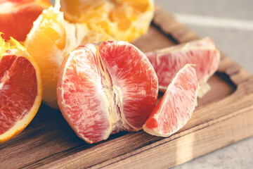 Peeled oranges on a wooden board on the kitchen table.
