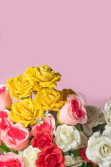 Bouquet of colorful roses on pink background with copy space.