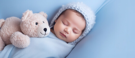 Newborn baby boy sleep, with empty copy space, on blue big bed