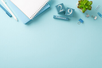 February's final workday captured: top-view photo with memo pads, pens, desk accessories, a small plant, and a date block for the 29th of February, on a gentle blue surface, leaving space for wording - obrazy, fototapety, plakaty