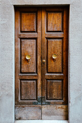 Elegant old double door entrance of building in Europe. Vintage wooden doorway of ancient stone house. Simple brown wood door. Architecture in Italy.