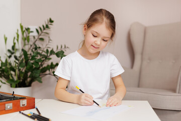 Cute little girl drawing something with pencils