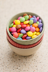 Colorful sweet candies in bowl on kitchen table.