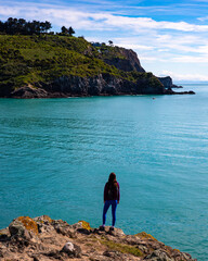 hiker girl enjoying a sunny day at godley head walkaway near christchurch, canterbury, new zealand;...