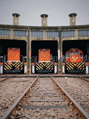 In the fan-shaped garage, an orange-red locomotives are parked.