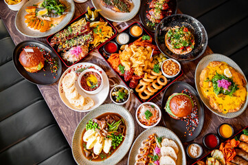 variety of restaurant food dishes on table. top view.