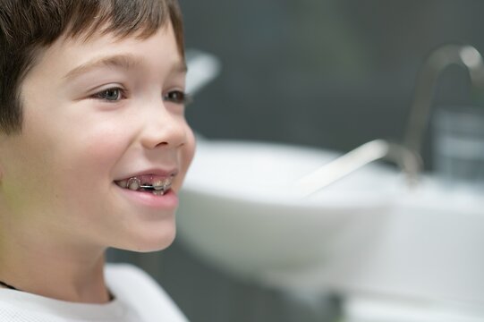 The boy inserts an orthodontic plate in his mouth