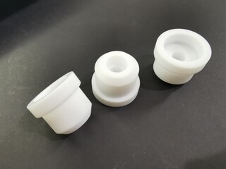 Teflon white, Industrial machinery spare parts, Black background. engineering materials, PTFE (Polytetrafluoroethylene) technical plastics.CNC, milling.