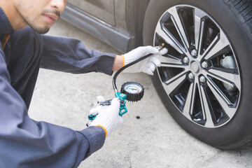 Auto mechanic man checking tire measure air pressure, measurement with gauge for car tyre, mechanic...