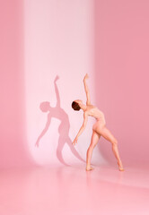 Blush Ballet. Young woman, ballerina, dancer in pink attire poses against pastel studio backdrop....