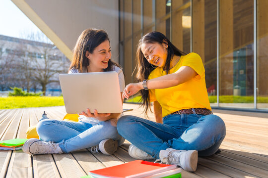 Students Sitting On The Ground In The Campus Using Laptop