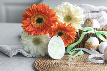 Easter composition with gerbera flowers and decorative eggs in a basket.
