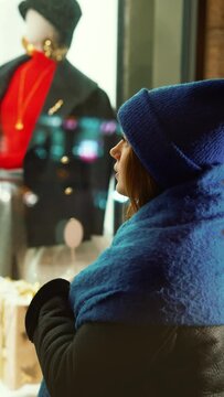 Woman in blue knit hat and fur collar gazes longingly at mannequin, her wistful expression reflecting yearning for unattainable winter fashion. Latest winter fashion trends. Essence of seasonal style
