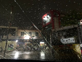 Rain drops on window windshield jaw drop in city at night travel