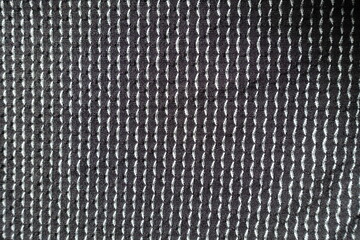 View of black and white jersey fabric with geometric pattern from above