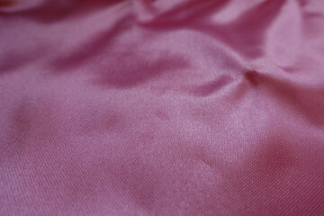 Close up of cold pink satin polyester fabric